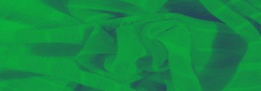 Yumuşak kıvrımları ve kıvrımları olan dokulu yeşil bir kumaşın bulanıklığı. Yeşilin canlı tonu ona taze, dinamik bir his veriyor. Soyut ya da arka plan tasarımları için mükemmel..