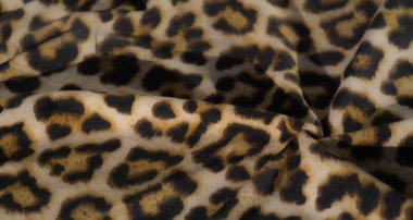 Sarı, siyah ve bej karışımı zengin leopar desenli pürüzsüz, akışkan kumaşı bulanıklaştırın. Yumuşak dokusu ve detaylı baskısı moda ve ev dekorasyonu için ideal hale getiriyor..