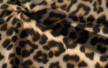 Siyah ve sarı hayvani desenli bulanık kumaş. Yumuşaklığı ve karmaşık kıvrımları güzel bir şekilde yakalıyor. Dinamik ışık ve doğal gölge oyunuyla..