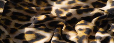 Parlak bir kumaşın bulanıklığı, karmaşık leopar benzeri altın ve siyah desenler sergiliyor, doğal kıvrımlar dinamik görünümünü artırıyor. Lüks tasarımlar için ideal, vahşi ve egzotik bir hava yayıyor..