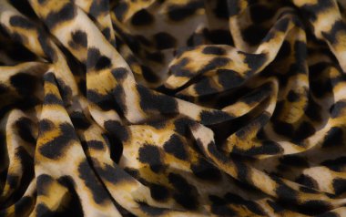 Bulanık, bu canlı leopar desenli kumaş sarı, siyah ve bej renkli gösteriler karmaşık kıvrımlar ve lüks bir doku, cesur ve dinamik bir moda sunuyor..