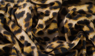 Görüntü, kalın leopar desenleri sıcak sarı, siyah ve bej tonlarını bir araya getirerek doğanın egzotik güzelliğini taklit eden dokulu ve lüks bir tasarım oluşturuyor..