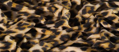 Bulanık, bu kumaş siyah lekeli, sarı ve bej arkaplanlı çarpıcı bir leopar deseni içeriyor. Lüks çekiciliğini arttıran vahşi ve egzotik bir doku sağlıyor..