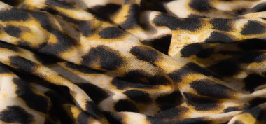 Bulanık, bu canlı leopar desenli kumaş sarı, siyah ve bej renkli gösteriler karmaşık kıvrımlar ve lüks bir doku, cesur ve dinamik bir moda sunuyor..