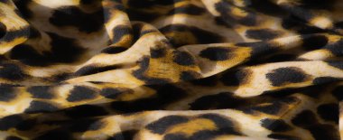 Bulanık, bu kumaş siyah lekeli, sarı ve bej arkaplanlı çarpıcı bir leopar deseni içeriyor. Lüks çekiciliğini arttıran vahşi ve egzotik bir doku sağlıyor..