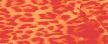 Parlak turuncu ve sarı bir kumaşın bulanık görüntüsü. Leopar desenine benzeyen koyu ve ateşli desenleri var. Yumuşak perdeler ve kıvrımlar derinlik yaratır, kumaşın dinamik görünmesini sağlar