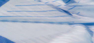 Yumuşak, dalgalı çizgileri ve parlak iplikleri olan açık mavi kumaş bulanıklığı. Hassas dokular ve parıldayan detaylar kumaşa ruhani ve sanatsal bir görünüm kazandırıyor..