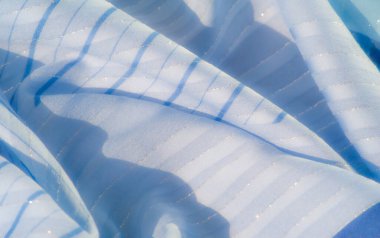 Bulanık mavi kumaş, yatay çizgiler ve parıldayan ışıltılar. Soyut kıvrımlar, dinamik bir ışık ve gölge oyunu yaratarak, sakin ama zarif bir görünüm sunuyor.