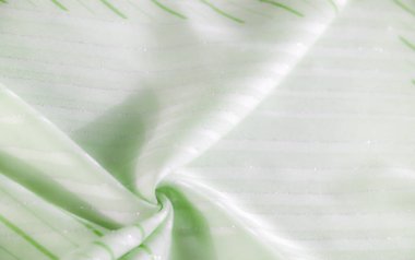 Bu açık yeşil kumaş yumuşak ışık altında parıldayan yatay çizgilere sahiptir. Yumuşak dokular ve yumuşak gölgeler yumuşak kıvrımlı sakin ve soyut bir tasarım oluşturur..