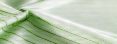 Bu açık yeşil kumaş yumuşak ışık altında parıldayan yatay çizgilere sahiptir. Yumuşak dokular ve yumuşak gölgeler yumuşak kıvrımlı sakin ve soyut bir tasarım oluşturur..