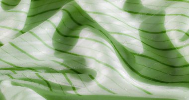 Parlak aksanlı bulanık yeşil kumaş ve yatay çizgiler. Yumuşak kumaşlar zarifçe örtülür ve titreşen detaylar kompozisyona biraz lüks katar..