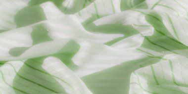 Bulanık, bu resim ince parlak çizgileri ve yumuşak beyaz çizgileri olan yumuşak yeşil kumaşı ön plana çıkarıyor, hassas kıvrımları olan pürüzsüz ve yansıtıcı bir doku oluşturuyor..