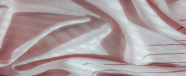 Yumuşak pembe kumaşlar, kırmızı çizgiler ve gümüş renkli gölgeler, akışkan bir doku yaratmak için nazikçe katlanmış, hem zarafet yayıyor hem de ışığın altında hafif bir parıltı.