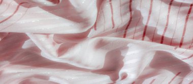 Işıldayan gümüş aksanlı açık pembe kumaş ve kırmızı çizgili desenler, ışığı yansıtan zarif dalgalar yaratmak ve lüks görünüşü geliştirmek için özenle katlanmış..