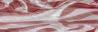 Pembe ve kırmızı çizgili, parlak gümüş aksanlı bir kumaş. Dalgalı çizgiler büyüleyici bir akış yaratır. Karmaşık kıvrımlar ve yumuşak yüzeyde ışık oyunu..