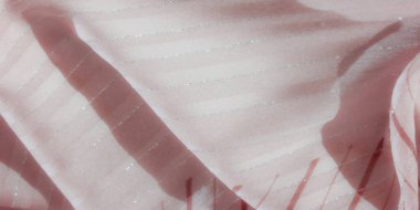 Kırmızı çizgili ve gümüş aksanlı pembe bir kumaşın bulanık görüntüsü. Işık dokulu yüzeyden yansıyarak ince dalgalarla ışıltılı ve yumuşak bir görünüm yaratır..