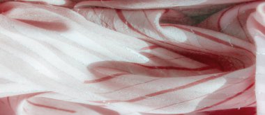 Hassas kırmızı dalgalı çizgileri olan pembe kumaş bulanıklığı ve pırıl pırıl gümüş bir aksan, akıcı ve yumuşak bir görsel doku yaratıyor. Tekstil, moda tasarımı ve soyut arka planlar için mükemmel..