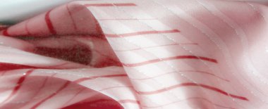 Zarif kırmızı kıvrımlı ve gümüş detaylı pembe kumaş bulanıklığı akıcı ve dinamik bir doku yaratıyor. Yaratıcı projeler, tekstil tasarımı veya soyut arkaplanlar için ideal.