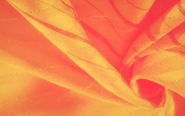 İnce çizgili bulanık sarı ve turuncu kumaş parlak ve soyut bir görüntü yaratır. Kumaşın dokularının akışı ve karmaşık desenleri sıcak renklerin uyumlu bir karışımını oluşturur..