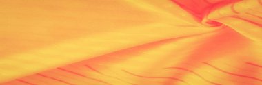 Dinamik kıvrımları ve yumuşak dokuları olan parlak turuncu ve sarı bir kumaş. Kumaşın akışı güzel, soyut bir model yaratır, canlı, yaratıcı arka planlar veya tasarımlar için mükemmeldir..