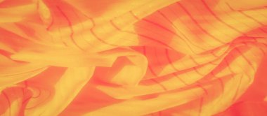 İnce parlak dokuları ve zarif kıvrımları olan sarı ve kırmızı çizgili bir kumaş. Yumuşak ve ılık renkler, tekstili narin ve büyüleyici gösteriyor..