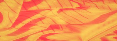 Kırmızı röfleli bulanık sarı kumaş nazikçe örtüyor ve zarif bir görsel desen oluşturuyor. İnce doku ve akış çizgileri bu tasarımı hem sakinleştirici hem de sanatsal yapıyor.,