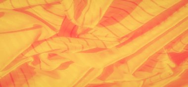 Yumuşak kıvrımlı sarı ve turuncu kumaşların bulanık görüntüsü ve çizgili desenler üzerinde hafif ışık efektleri.