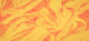 Bulanık turuncu ve sarı kumaşlar ince çizgili girdaplar büyüleyici bir soyut desen oluşturuyor. Yumuşak kıvrımlar ve parıldayan aksanlar sıcaklık ve akıcılık hissi uyandırıyor..