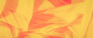 Yumuşak sarı kumaştan ince turuncu eğimli ve köşegen çizgili bulanık dokular akıcı dokular ve nazik kıvrımlar zarif, sıcak tonlu soyut desenler yaratıyor tekstil veya tasarım projeleri için mükemmel.