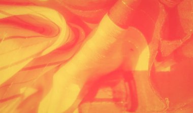 İnce çizgili aksanlı, parlak ışık yansımalı pürüzsüz sarı bir kumaşın bulanıklığı. Yumuşak doku ve canlı rengin kombinasyonu sanatsal kullanım için sıcak, soyut bir görsel yaratıyor..