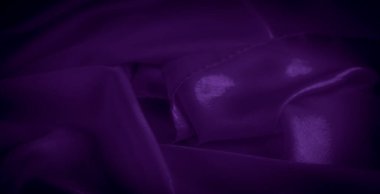 Yakın plan zengin mor saten kumaş, zarif kıvrımlarını ve pırıl pırıl parıltısını gözler önüne seriyor. Lüks ve sofistike görünmek için mükemmel. Yumuşak dokusu arka planlar ve moda projeleri için idealdir.