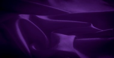 Derin mor saten kumaş bulanıklığı zarif bir şekilde akıyor ve kıvrılıyor, parlak dokusu yumuşak bir parıltıyı yansıtıyor. Lüks malzemenin zengin, canlı bir rengi var, şık bir şey yaratıyor.