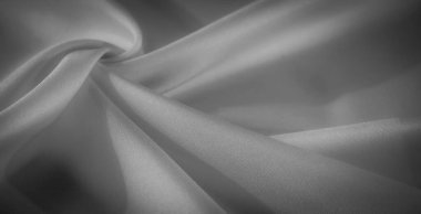 Yumuşak kıvrımları ve kıvrımları olan akışkan tek renkli kumaş bulanıklığı. Gölgeler ve ışığın etkileşimi ince bir doku ekler, minimalist tasarım ise karmaşıklığı çağrıştırır..