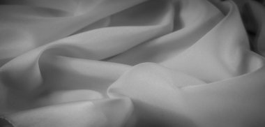 Yumuşak kıvrımları ve yumuşak dokuları olan bulanık gri tonlu kumaş hafif bir ışık ve gölge oyunu yaratıyor. Bu çok yönlü kumaş tasarımı arka plan ve modern tekstil projeleri için mükemmeldir..