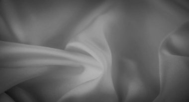 Yumuşak kıvrımlı bulanık gri tonlu kumaş ve hafif bir ışık ve gölge etkileşimi, sakin ve pürüzsüz bir doku yaratıyor. Bu görüntü moda, tekstil tasarımı ve sanatsal altyapı için idealdir..