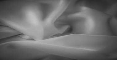 Zarif kıvrımları olan bulanık gri tonlu kumaş pürüzsüz ve yumuşak bir yüzeyde ışık ve gölge dengesini yakalıyor. Sanatsal altyapı, tekstil tasarımı veya moda ile ilgili projeler için mükemmel..