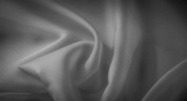 Yumuşak kıvrımlı, ipeksi, dalgalı gri kumaş, pürüzsüz ve rafine bir doku yaratıyor. İnce ışık yansımaları bu soyut örtüdeki lüks ve sofistike hissi artırır.