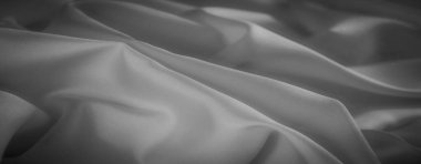 Gri tonda yumuşak kıvrımlı kumaş bulanıklığı yumuşak bir ışık yansıması ile pürüzsüz ve lüks malzemeyi sergiliyor. Hassas kumaş yumuşak ve sakin bir atmosfer yaratır.