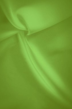Canlı yeşil kumaş bulanıklığı, karmaşık kıvrımlar ve ışık yansıması ile yumuşak, akan bir yüzey yaratır. Kumaşın lüks dokusu soyut ya da moda tasarımları için mükemmel bir zemin sağlar..