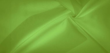 Narin yeşil kumaş yumuşakça bulanıklaşır, ışığı yakalar ve kıvrımlarda doğal bir akış yaratır, bu da izleyiciye sofistike ve huzurlu bir görüntü verir..