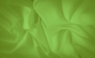 Yumuşak kıvrımlı parlak yeşil kumaş ve ince bir doku. Görüntü akıcı, akıcı bir görünüme sahip, sanatsal arka planlar veya moda tasarımı için mükemmel..