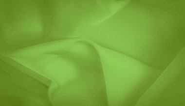 Parlak yeşil bir kumaşın bulanıklığı, kıvrımlı, yumuşak görünümlü, sıvı kıvrımlı. Kumaşın canlı rengi ve pürüzsüz yüzeyi onu tekstil sanatı ve arka plan tasarımları için çok yönlü bir seçim yapar..