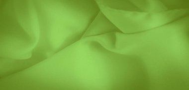 Yumuşak, akışkan kıvrımları olan canlı yeşil kumaşın güzel bir görüntüsü. Doku pürüzsüzlüğü vurguluyor ve kıvrımlar nazik gölgeler oluşturuyor. Yaratıcı amaçlar için çekici bir görüntü sunuyor..