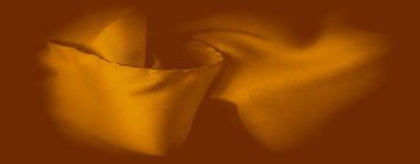 Bulanık altın-turuncu kumaş dalgalar halinde nazikçe katlanır, sakin ve zarif bir doku akışı yaratır. Işık yüzeyden hafifçe yansıyor, kumaşın lüks hissini vurguluyor..