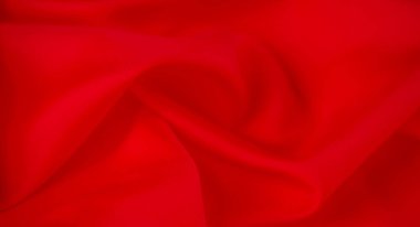 Yumuşak kıvrımlara sarılı parlak kırmızı kumaş bulanıklığı, zengin kırmızı renk dinamik ve lüks bir doku yaratır. Kumaş pürüzsüz akıyor, canlı rengini ve ince tekstil kalitesini gösteriyor..