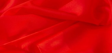 Zarif, akıcı kıvrımlar oluşturan kırmızı kumaşın bulanıklığı, lüksü çağrıştıran pürüzsüz dokusu, yumuşak ve zarif bir tekstil arkaplanı yaratıyor.