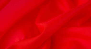 Yumuşak kıvrımlı, yumuşak kırmızı kumaştan bulanık, yumuşak kıvrımlar ve ipeksi bir doku sergiliyor. Rengi derinlik ve enerji katıyor, tekstil projeleri veya moda kavramları için mükemmel..