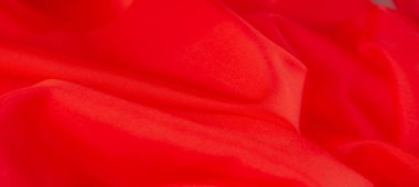 Yumuşak kıvrımlı, yumuşak kırmızı kumaştan bulanık, yumuşak kıvrımlar ve ipeksi bir doku sergiliyor. Rengi derinlik ve enerji katıyor, tekstil projeleri veya moda kavramları için mükemmel..