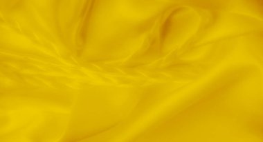 Yumuşak sarı bir kumaşın bulanık örgülü desenleri yüzey boyunca pürüzsüz bir şekilde sarmaş dolaş, kıvrımlar ve akış dokularıyla dinamik bir bileşim oluşturuyor..