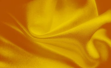 Narin örülmüş dokuları olan sarı bir kumaşın bulanıklığı. Pürüzsüz yüzey ve canlı sarı renk yaratıcı projeler için mükemmel zarif ve soyut bir görsel oluşturur..